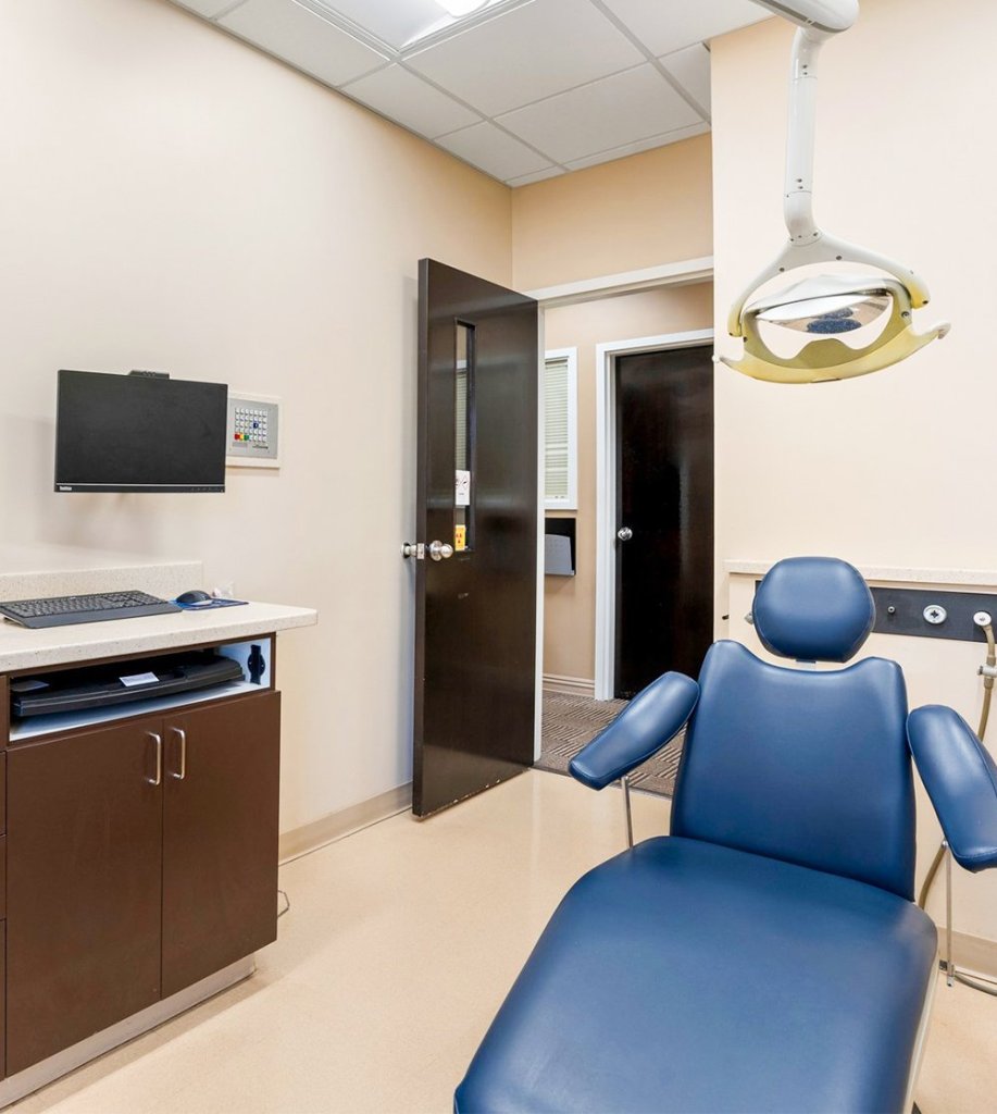 A clean and comforting exam room with a dental chair and overhead light
