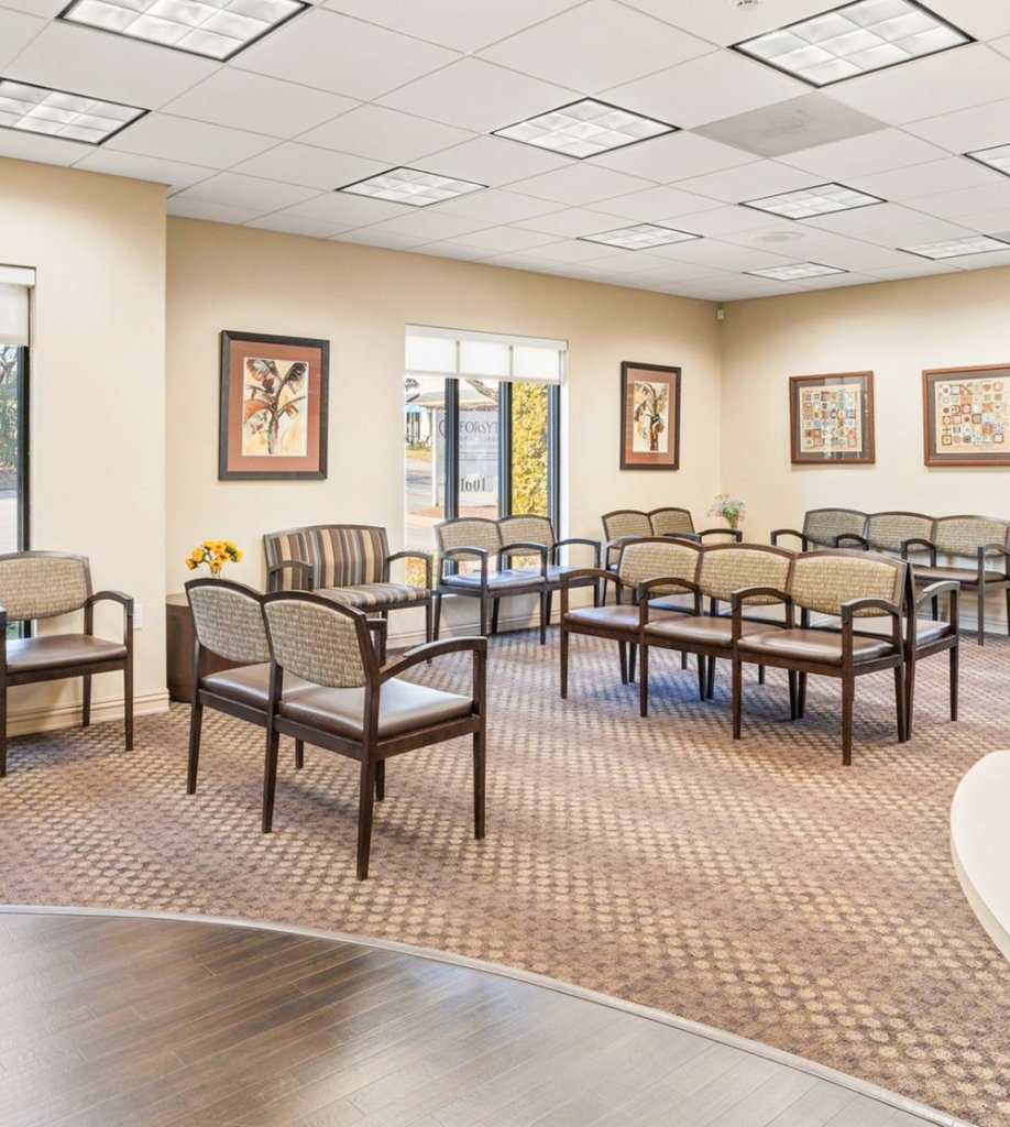 The lobby for the dental office, it has plenty of comfortable seating and nice art hanging on the walls.